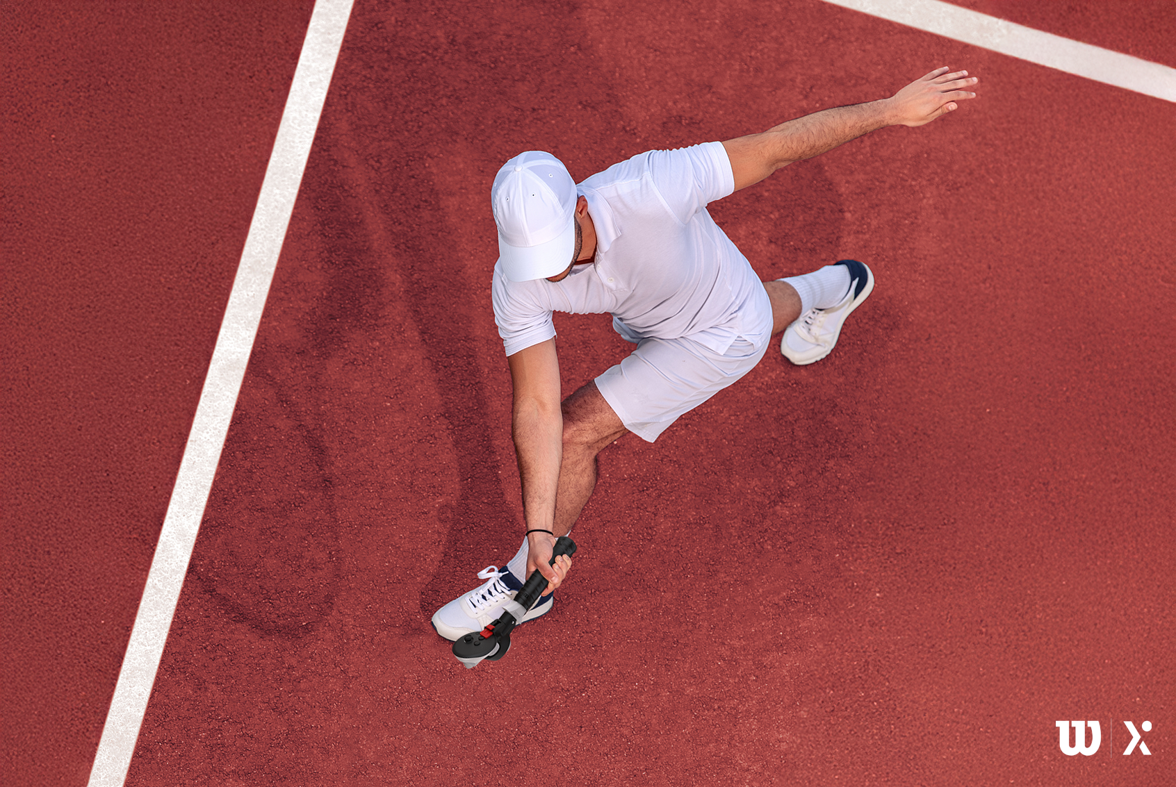 Tennis player in action on a red court